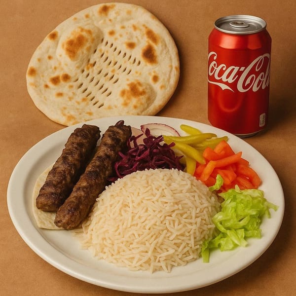 Erbil Kabob plate with two kabobs, rice, salad, pickled vegetables, flatbread, and a Coca-Cola can.