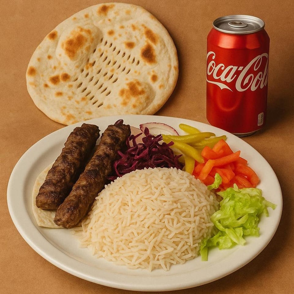 Erbil Kabob plate with two kabobs, rice, salad, pickled vegetables, flatbread, and a Coca-Cola can.